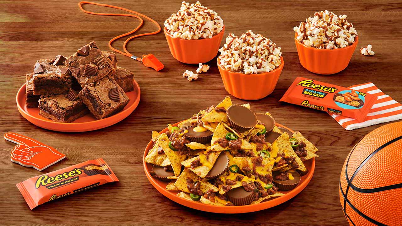 trays and bowls of assorted game day snacks made with reeses peanut butter and caramel cups